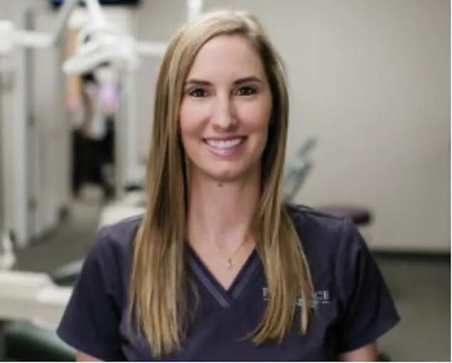 a woman in a dental office is smiling for the camera .
