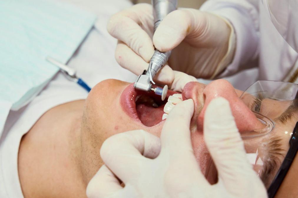 a man is getting his teeth cleaned by a dentist .