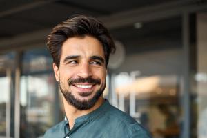 a man with a beard is smiling and looking at the camera .