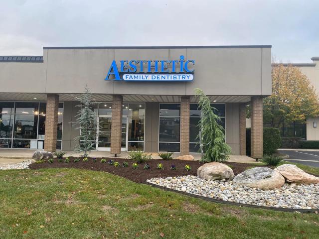 the front of a dental office with a blue sign that says aesthetic family dentistry .