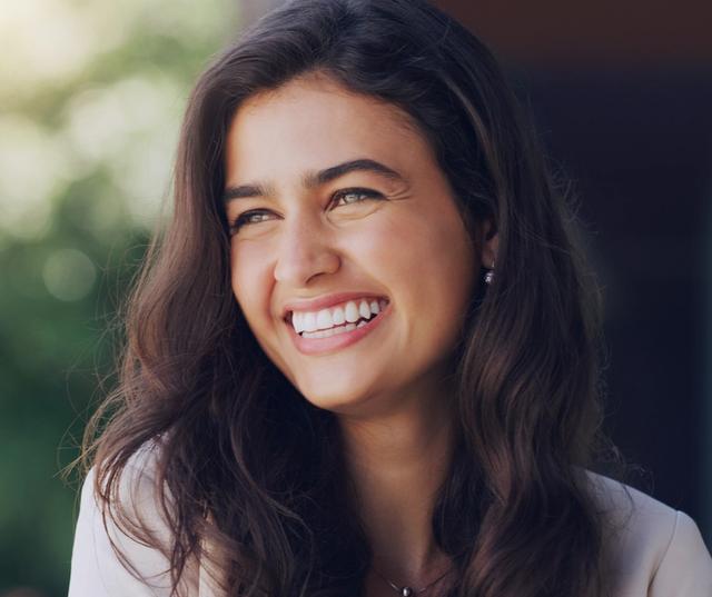 a close up of a woman smiling with her eyes closed .