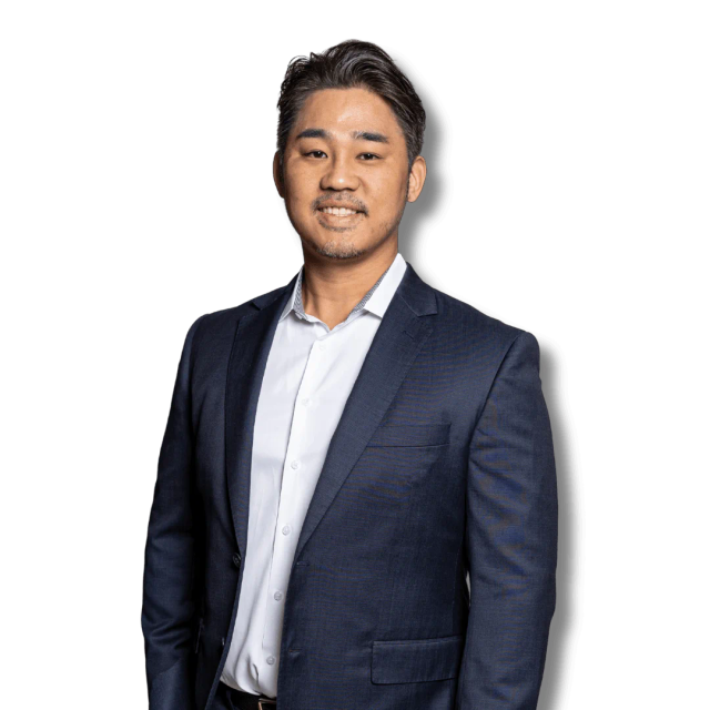 a man in a suit and white shirt stands in front of a blue background