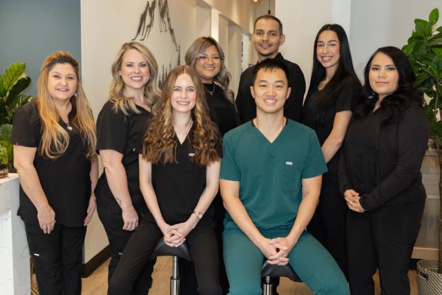a group of people in scrubs are posing for a picture .