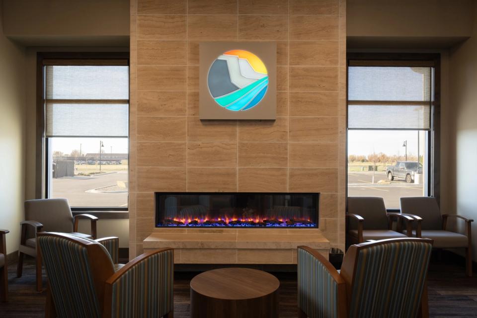 a living room with a fireplace , chairs and a table .