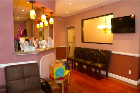 a waiting room with chairs and a tv on the wall