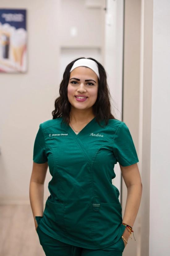 a woman wearing a green scrub top with the name andrea on it