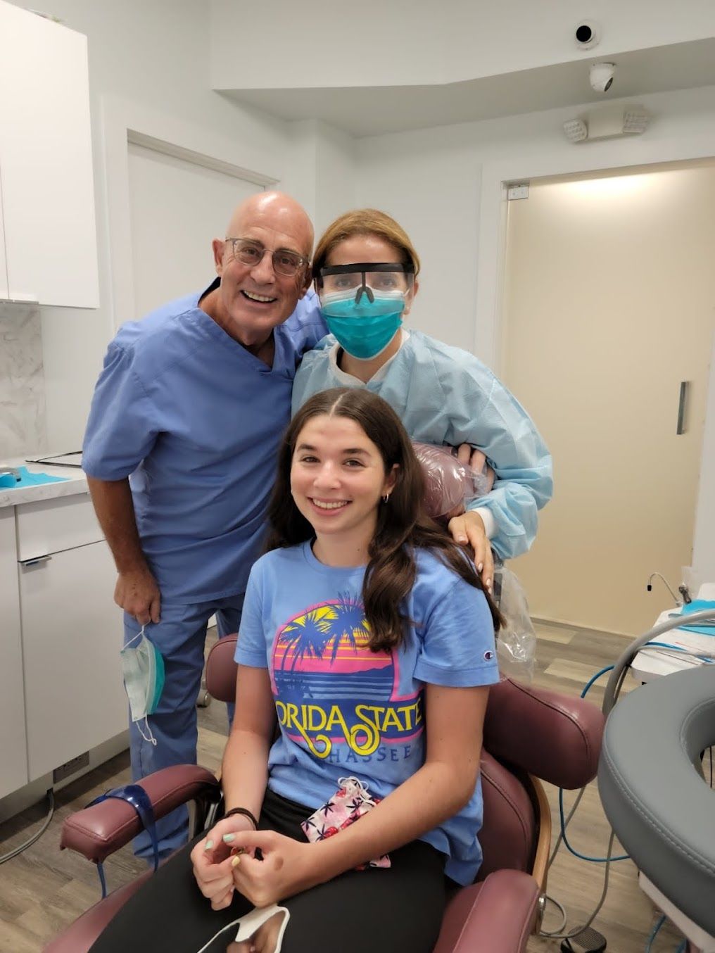a girl in a florida state shirt sits in a dental chair