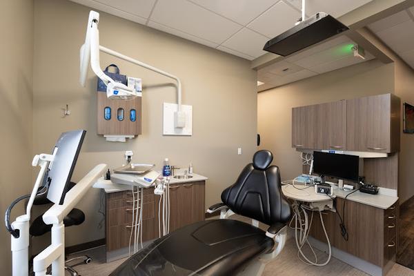 a dental office with a dental chair and a computer .
