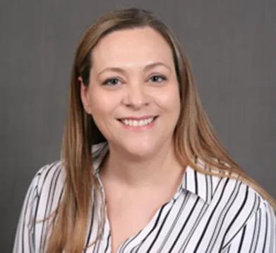 a woman in a striped shirt is smiling for the camera .