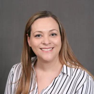 a woman in a striped shirt is smiling for the camera .