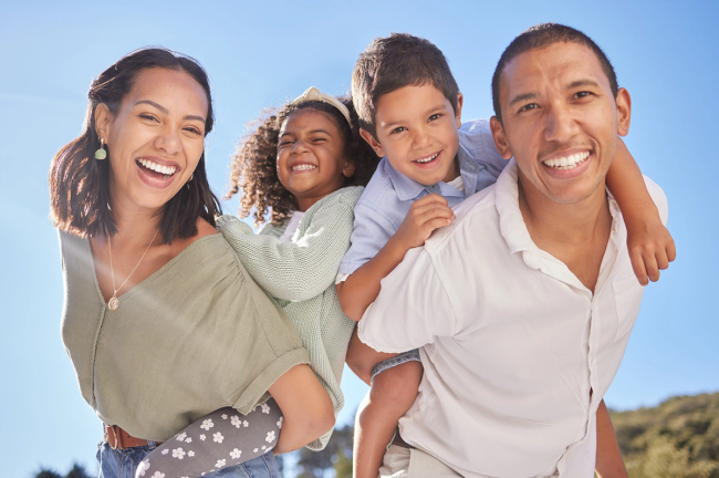 a family posing for a picture with a blue sky in the background