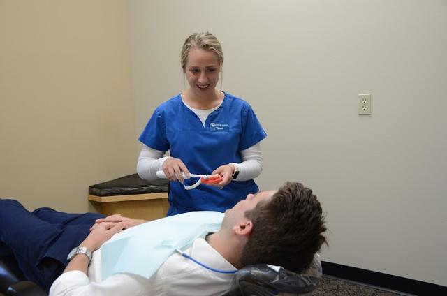 three women in blue scrubs are posing for a picture .