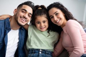 a family is posing for a picture together while sitting on a couch .