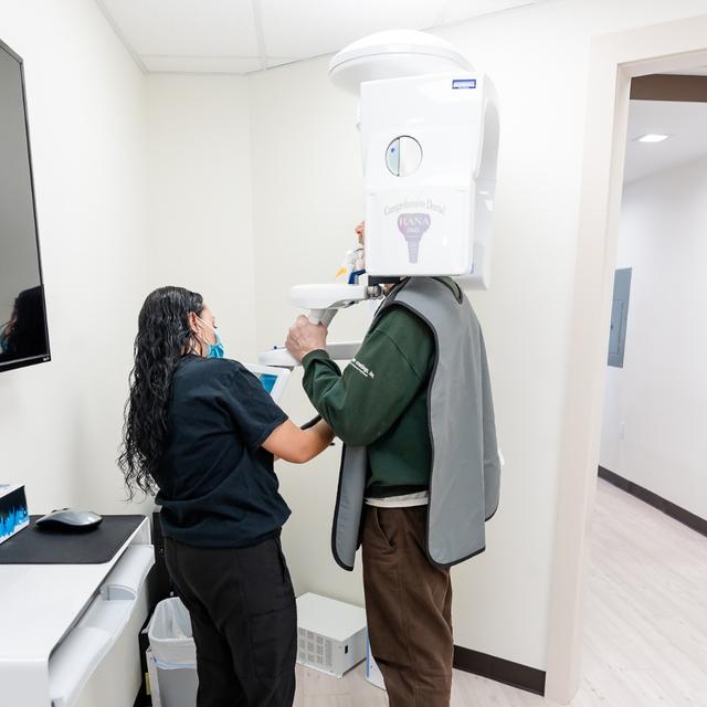 a man is getting an x-ray of his teeth in a dental office .