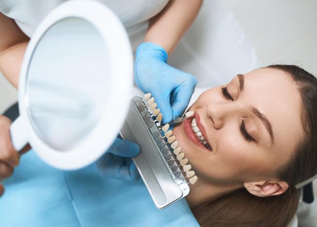 a woman is getting her teeth examined by a dentist .