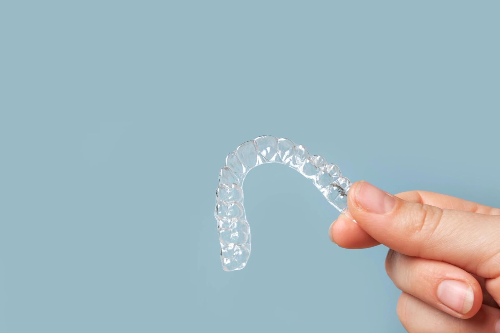 a person is holding a clear brace in their hand .