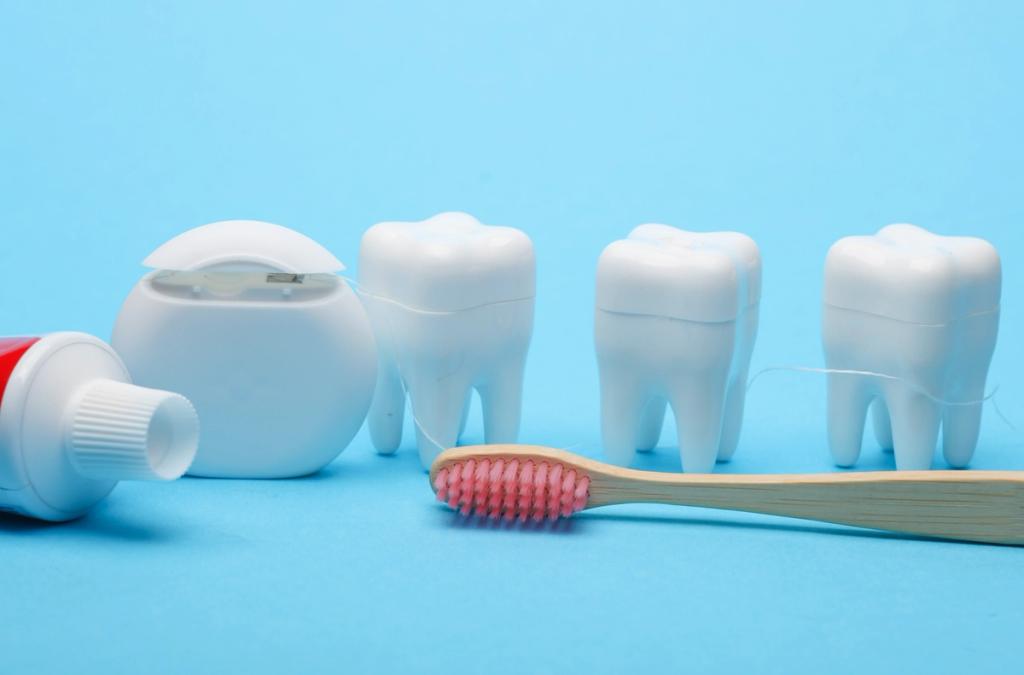 a toothbrush , toothpaste , floss and tooth models on a blue background .