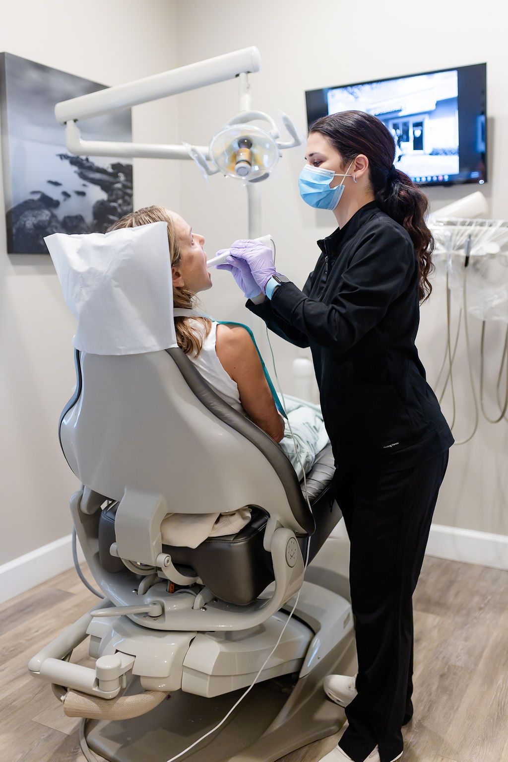 a woman in a dental chair getting her teeth examined by a dentist