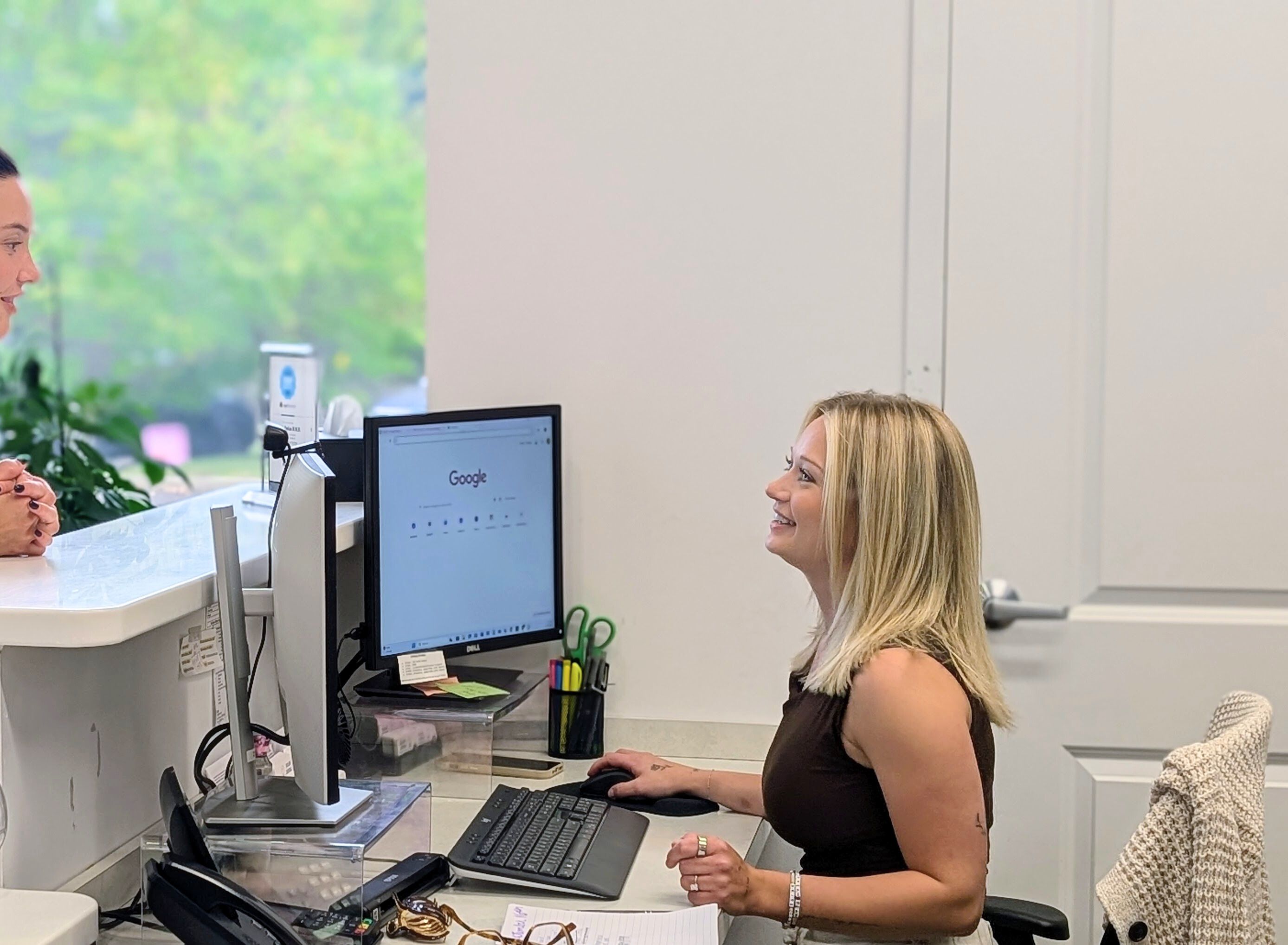 a woman is sitting at a desk in front of a computer .