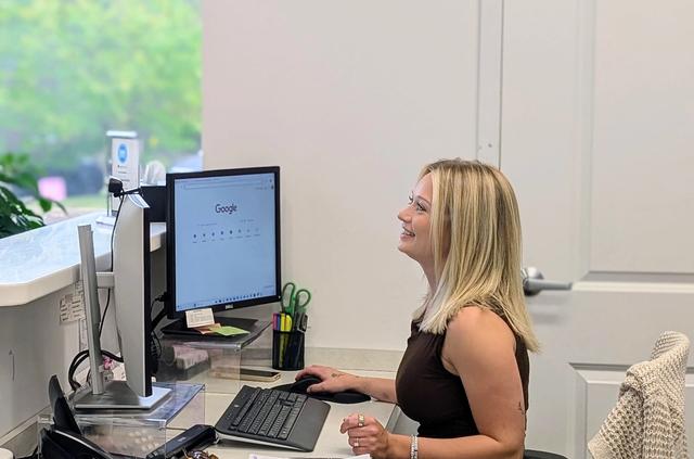 a woman is sitting at a desk in front of a computer .