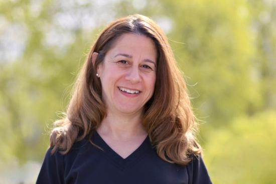 a woman in a black shirt is smiling for the camera .