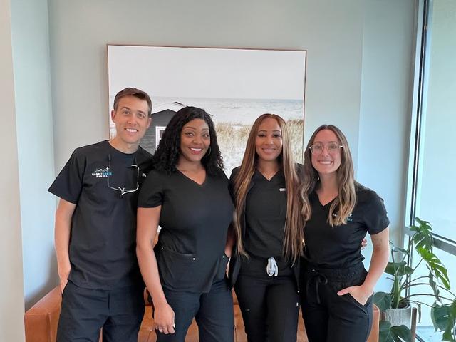a group of dental professionals are posing for a picture together .