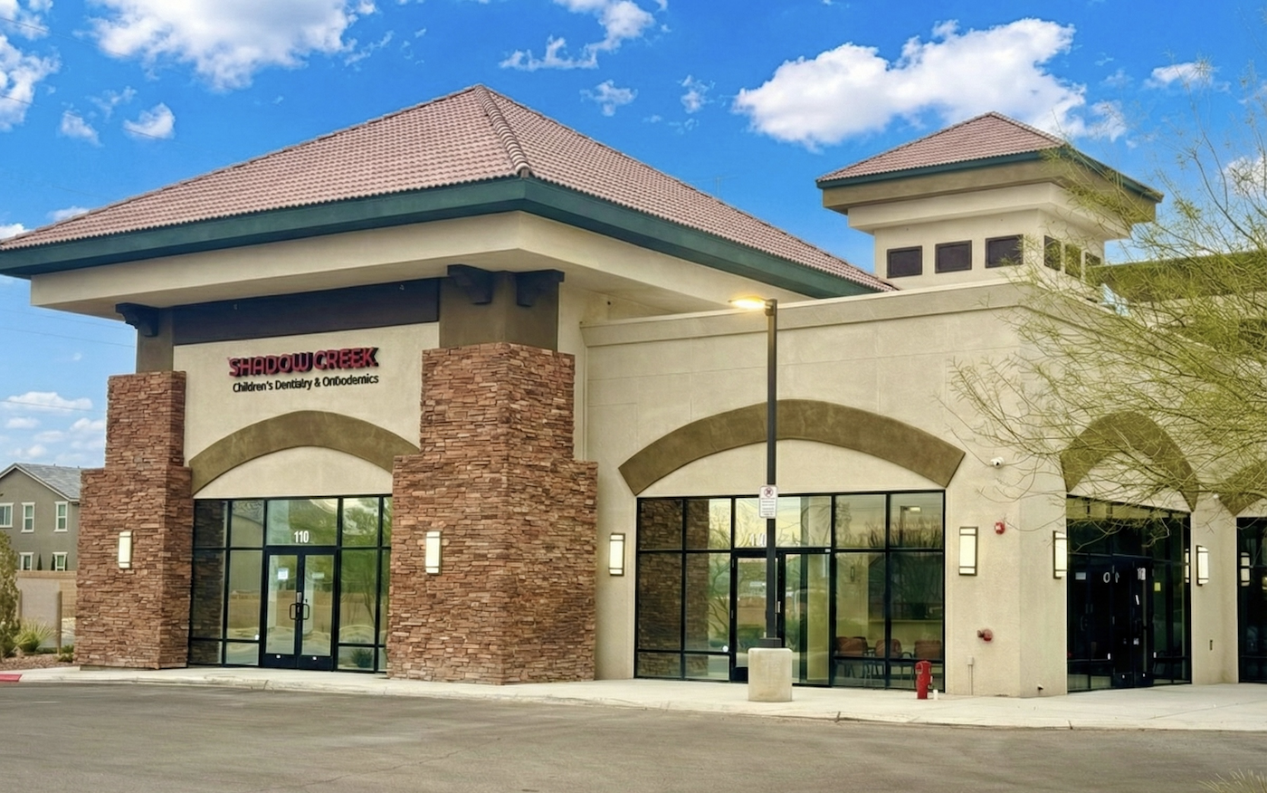 Exterior of Shadow Creek Children's Dentistry & Orthodontics, a modern building with stone accents and large windows.