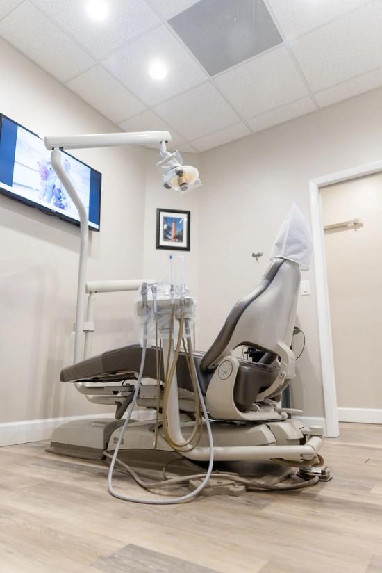 a dental office with a dental chair and a monitor