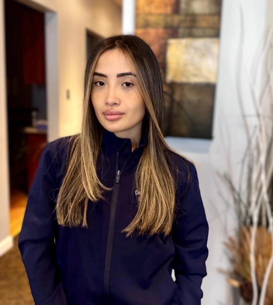 a woman in a blue jacket is standing in front of a painting .