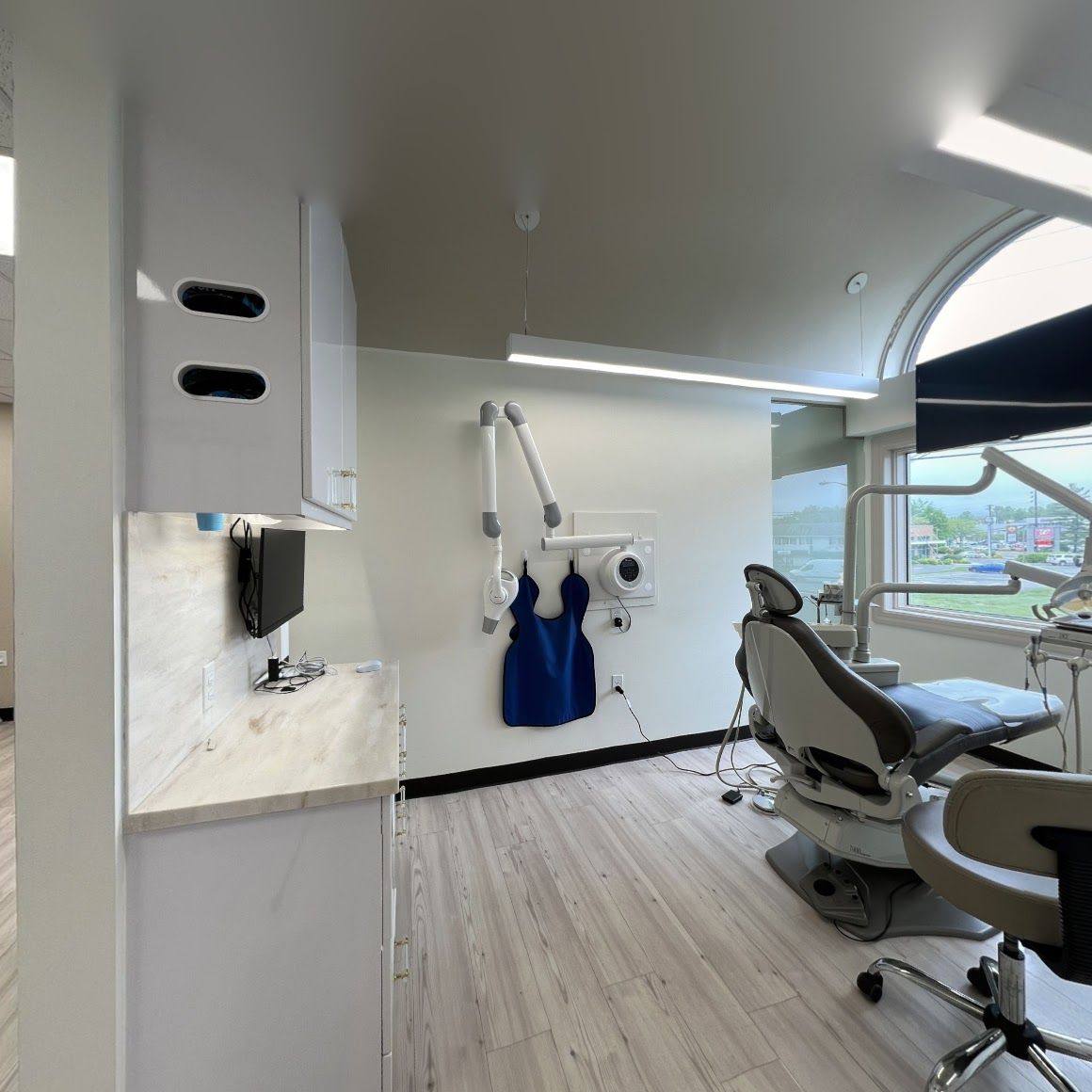 a dental office with a dental chair and an apron hanging on the wall .