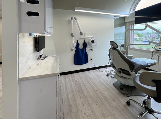 a dental office with a dental chair and an apron hanging on the wall .