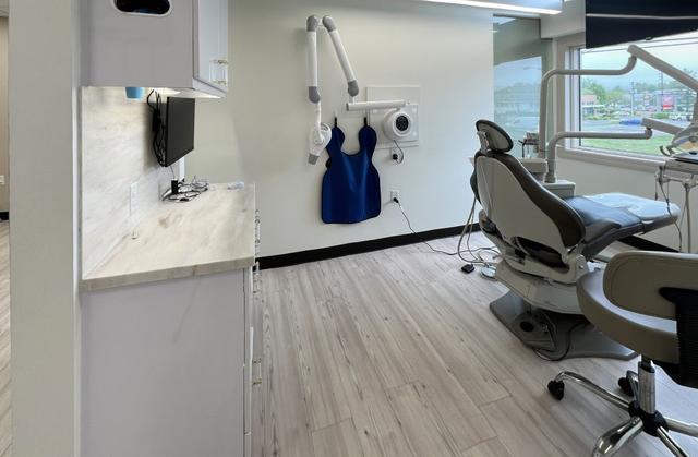 a dental office with a dental chair and an apron hanging on the wall .