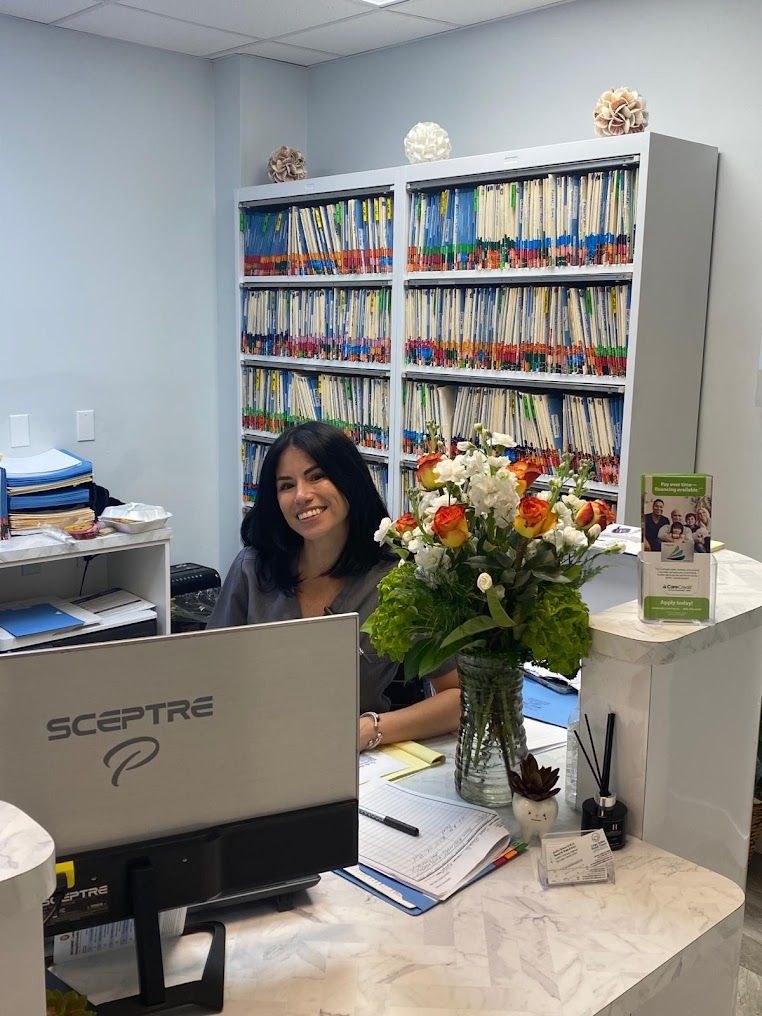 a woman sits at a desk in front of a sceptre computer