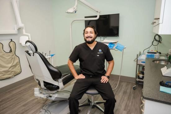 a man is sitting in a dental chair in a dental office .