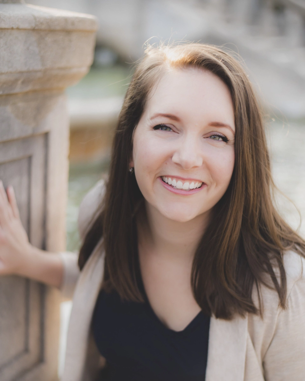 a woman with long brown hair is smiling for the camera