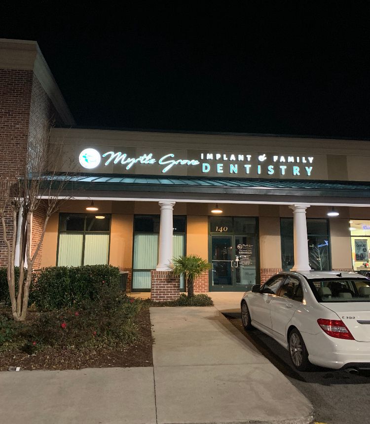 a white car is parked in front of myrtle grove dentistry