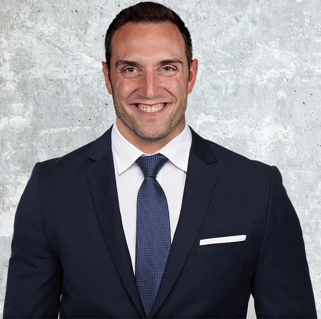 a man in a suit and tie is smiling for the camera .