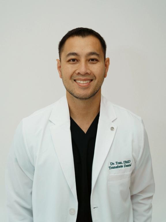 a man wearing a white lab coat with the name dr. true on it