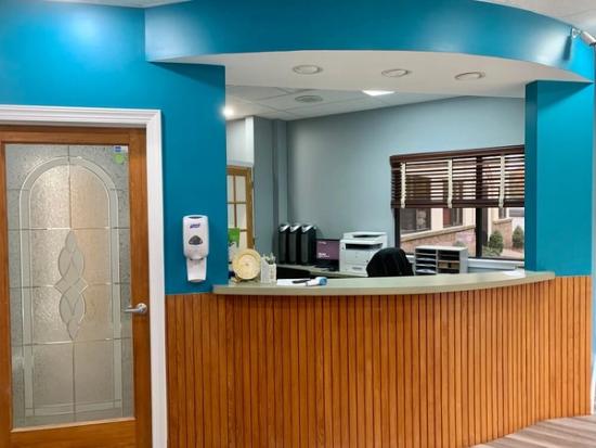 a dental office with a wooden counter and blue walls .