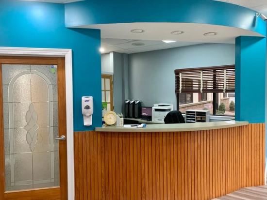 a dental office with a wooden counter and blue walls .