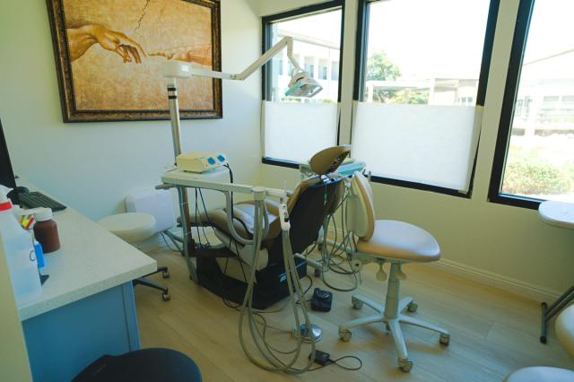 a dental office with a painting on the wall and a dental chair .