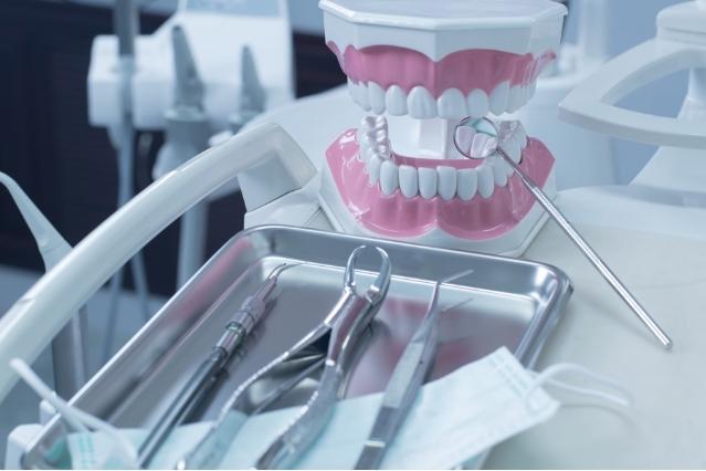a tray of dental instruments and a model of teeth on a dental chair .