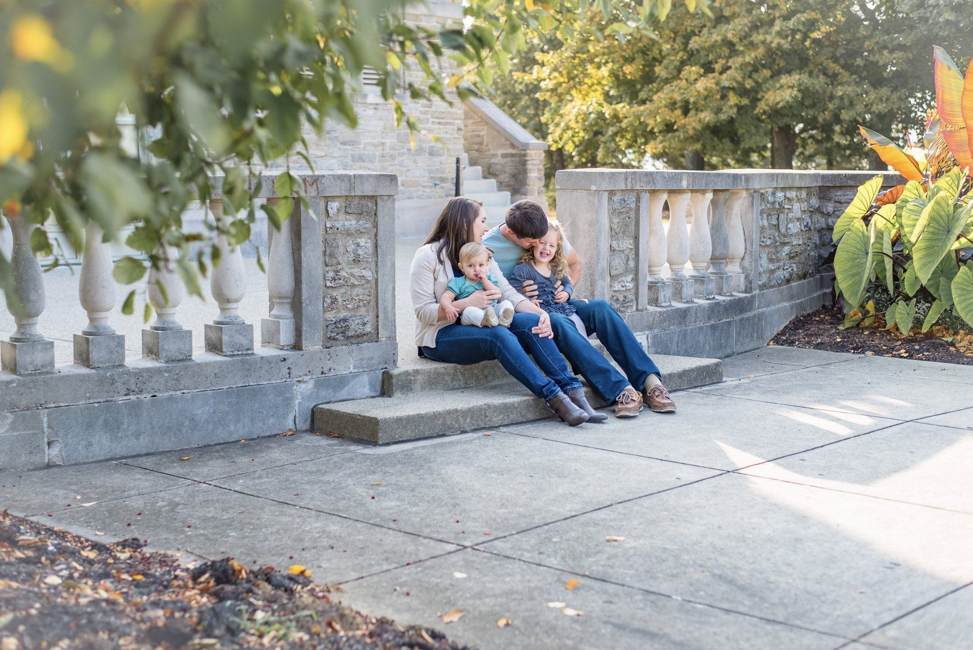 a family is sitting on the steps of a building .