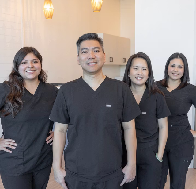 a group of people wearing black scrubs are posing for a picture