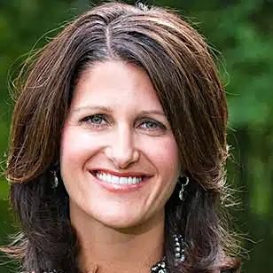 a woman with long brown hair is smiling for the camera .