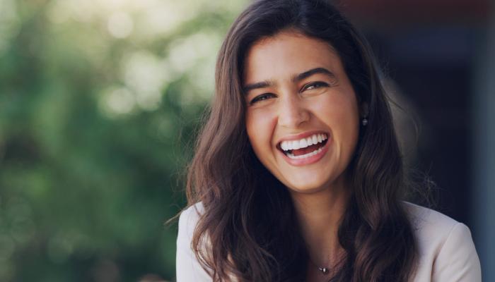a woman with long hair is smiling and looking at the camera .