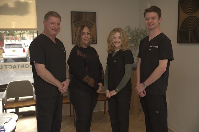 a happy family is taking a selfie on the beach .