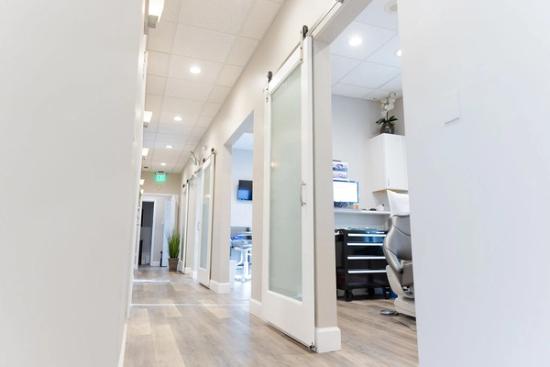 a long hallway in a dental office with sliding barn doors .