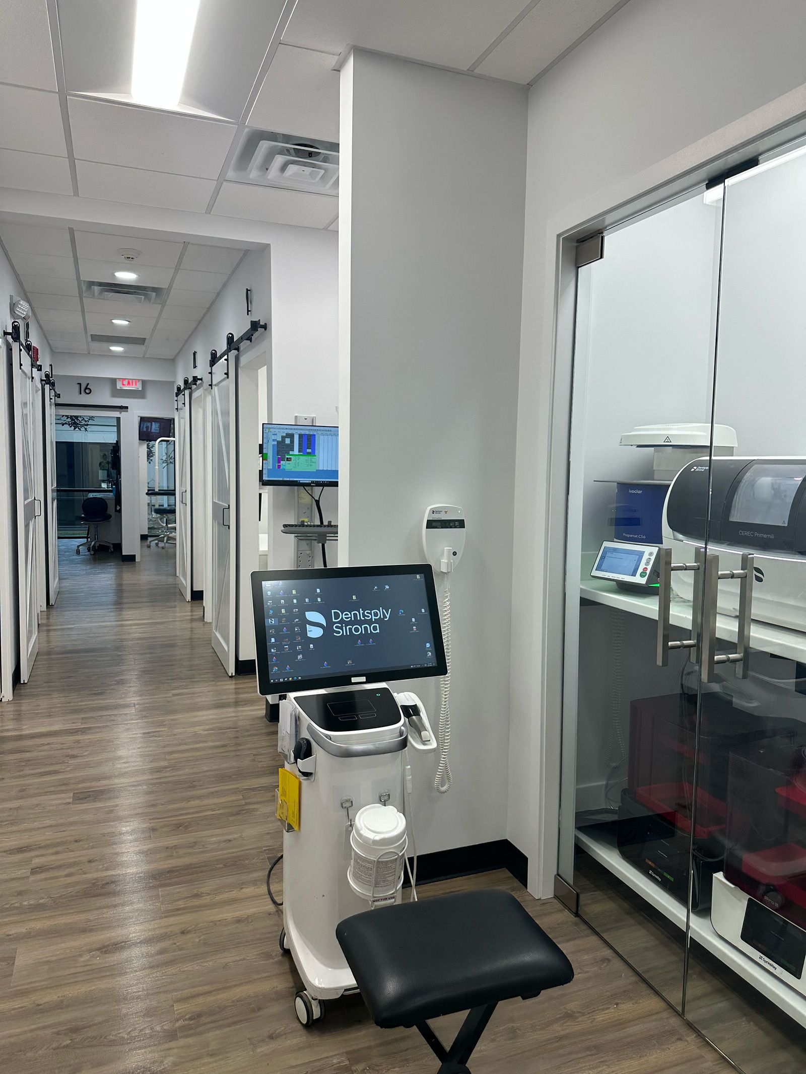 a dental office with a stool and a monitor that says dentistry studio