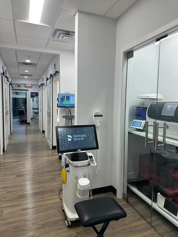 a dental office with a stool and a monitor that says dentistry studio